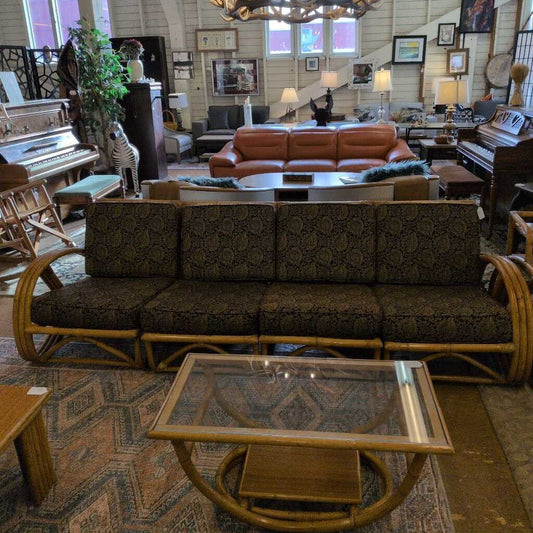 Living room with brown sofa, glass coffee table, and decorative items.