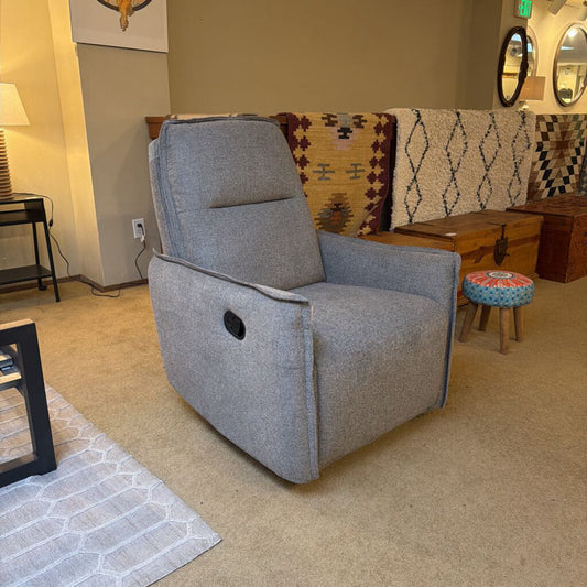 Gray recliner chair in a living room setting with decorative elements.