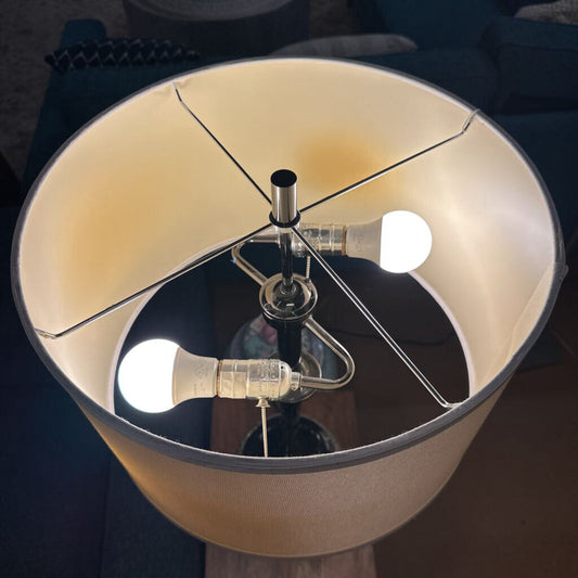 Close-up of a lamp with a broken glass shade and exposed bulb.