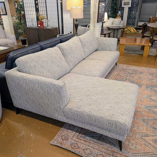 Gray sectional sofa in a room with furniture and decor