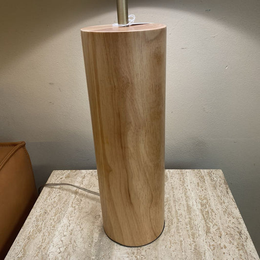 Wooden cylindrical lamp on a textured surface with a neutral background