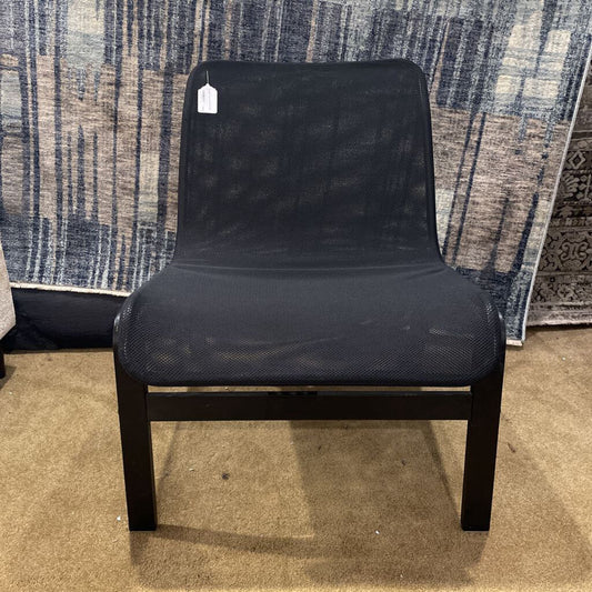 A low-profile armless accent chair with a black mesh seat and backrest on a simple black wooden frame.