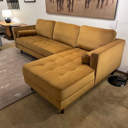 Orange sectional sofa and large golden print with cows