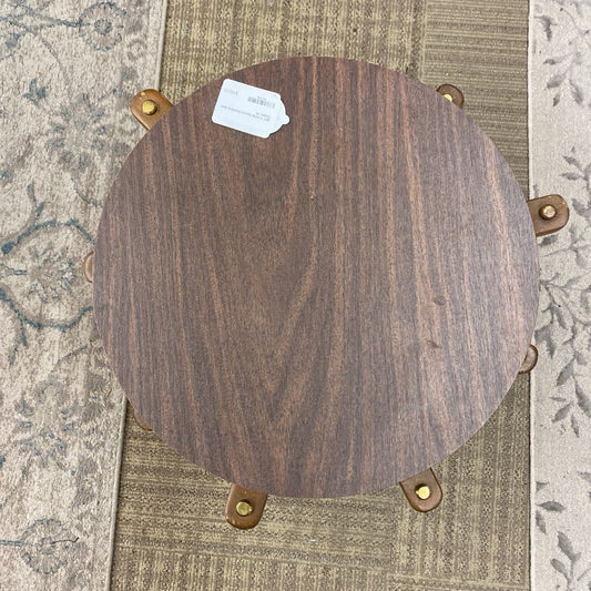 Wooden stool with four legs on a patterned rug