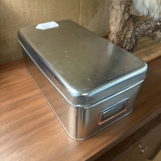 Metal storage box on a wooden surface with a blurred background