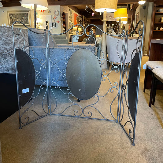 Decorative metal screen with round panels in a store setting