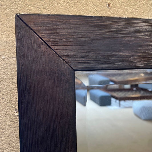 Close-up of a dark wooden frame with a blurred indoor setting in the background