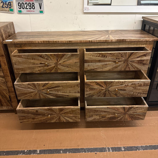 Wooden dresser with starburst pattern on a store floor