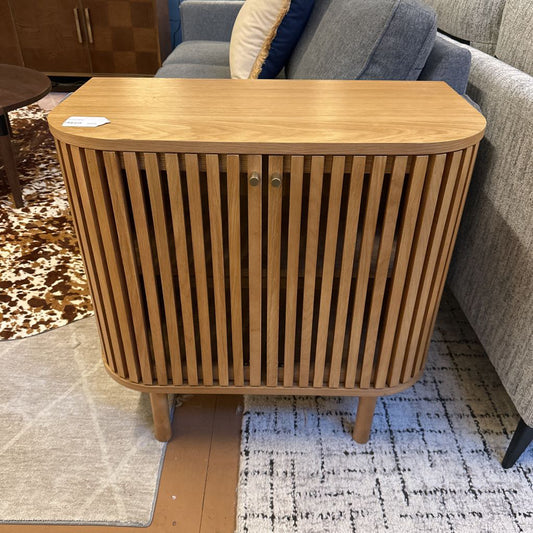 Wooden side table with slatted design in a living room setting