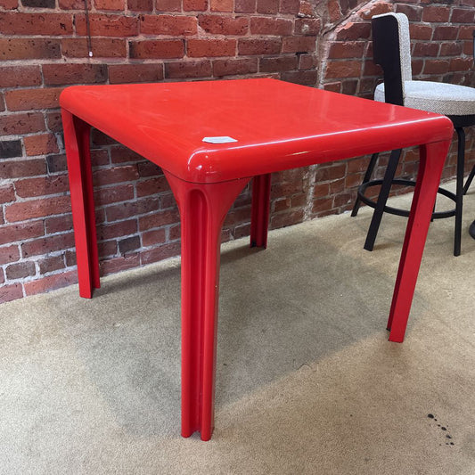 Red table against a brick wall