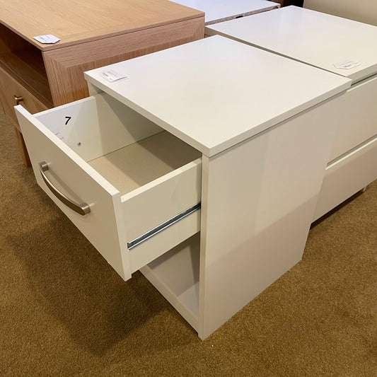 White cabinet with open drawer on a brown carpeted floor