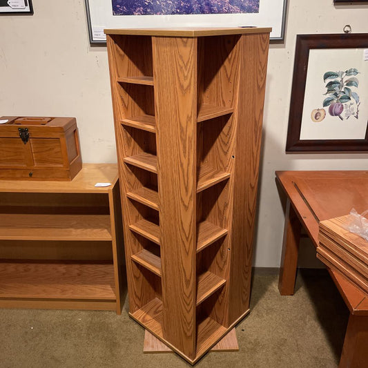 Wooden bookshelf with a plain wall and framed pictures in the background