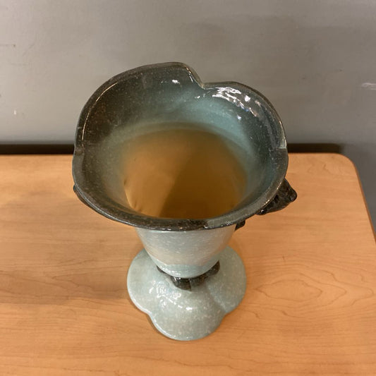Ceramic vase on a wooden surface with a neutral background