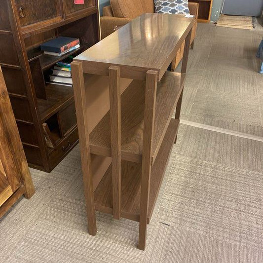 Wooden console table in a room with furniture and decor.