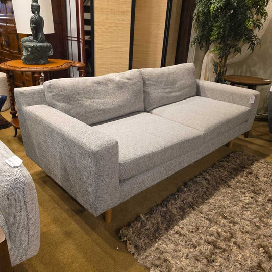 Gray sofa in a room with a rug and decorative items