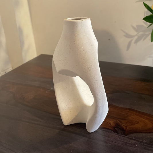 White ceramic vase on a wooden surface with a neutral background