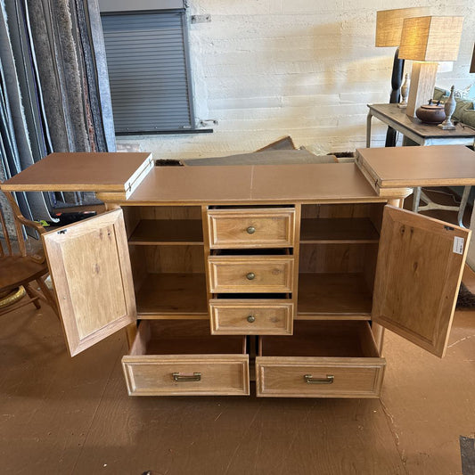 Wooden sideboard with open doors in a room setting