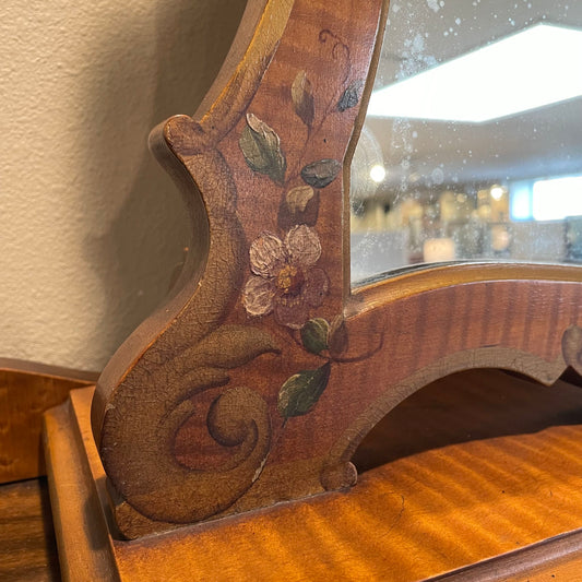 Wooden mirror with floral designs on a textured wall background