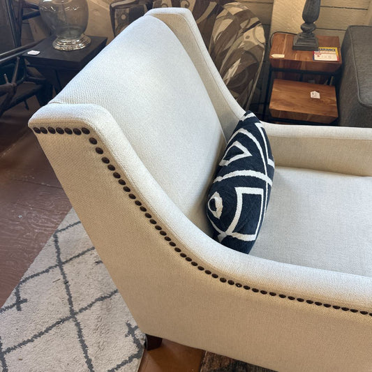 Beige armchair with a decorative pillow in a room setting