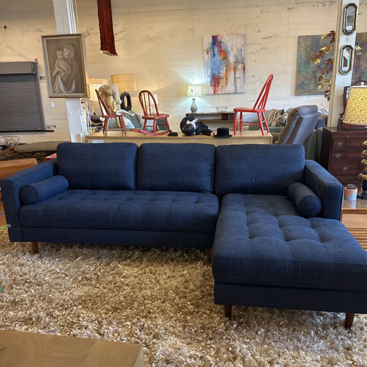 Blue sectional sofa in a living room with decorative elements.