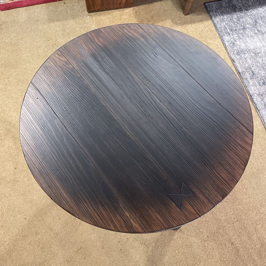 Round wooden table top on a carpeted floor