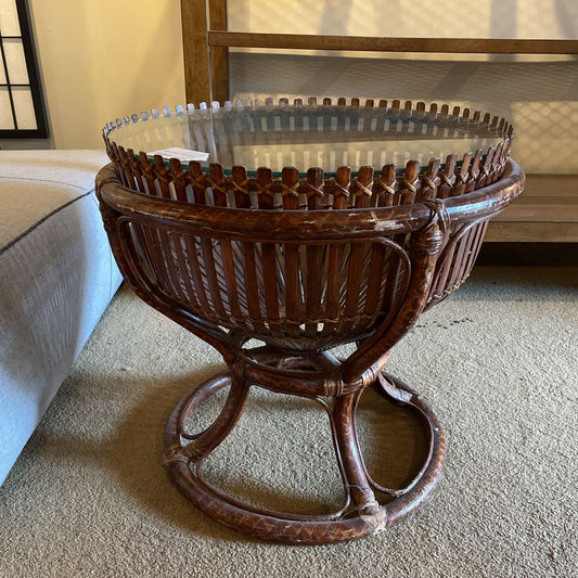 Wicker side table with glass top in a living room setting