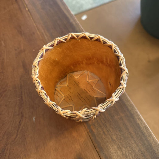 Woven basket with a star-shaped object inside on a wooden surface