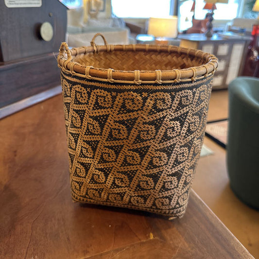 Woven basket with a geometric pattern on a wooden surface