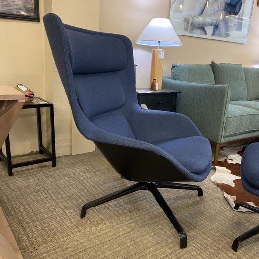 Blue armchair in a room with a lamp and sofa