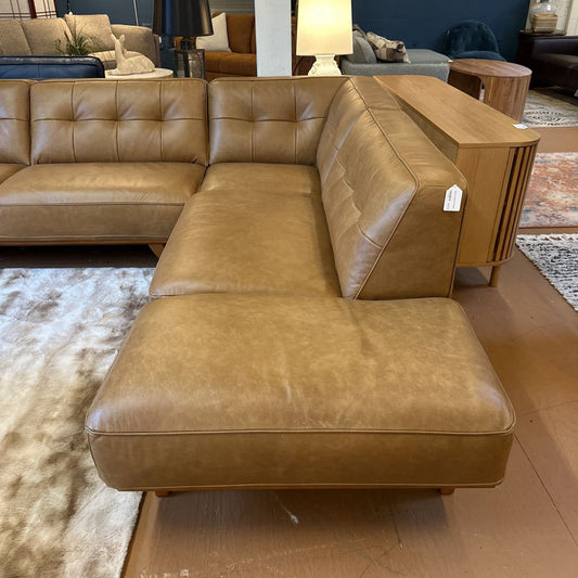 Brown leather sectional sofa in a room with other furniture.