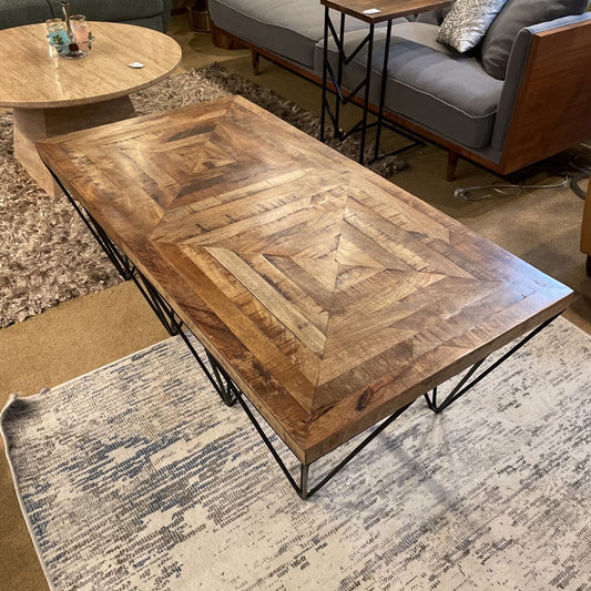 Wooden coffee table with geometric pattern in a living room setting