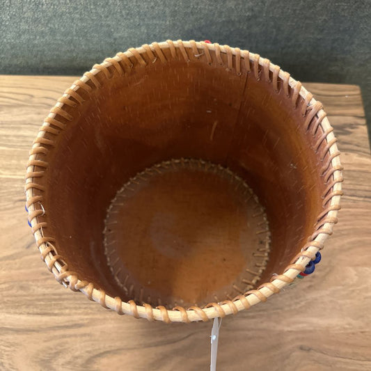 Woven brown basket on a wooden surface with a dark background