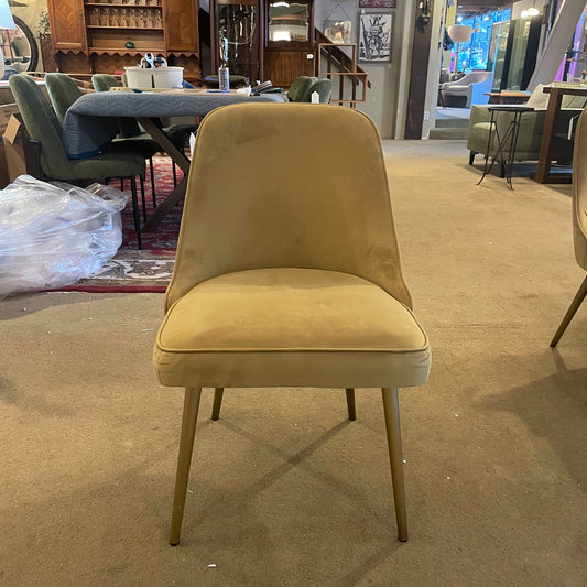 Beige chair in a showroom setting with other furniture in the background