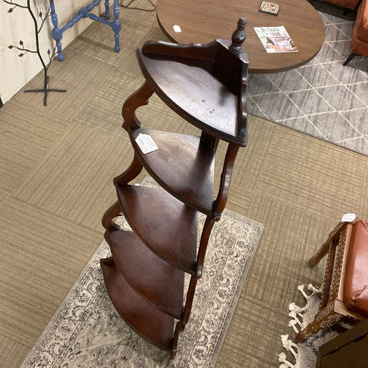 Wooden shelf with multiple tiers on a carpeted floor