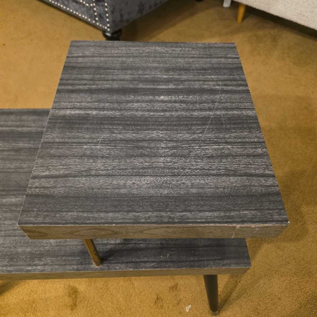 Two gray marble side tables on a wooden floor.