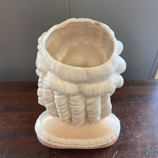 Decorative white vase with textured design on a wooden surface