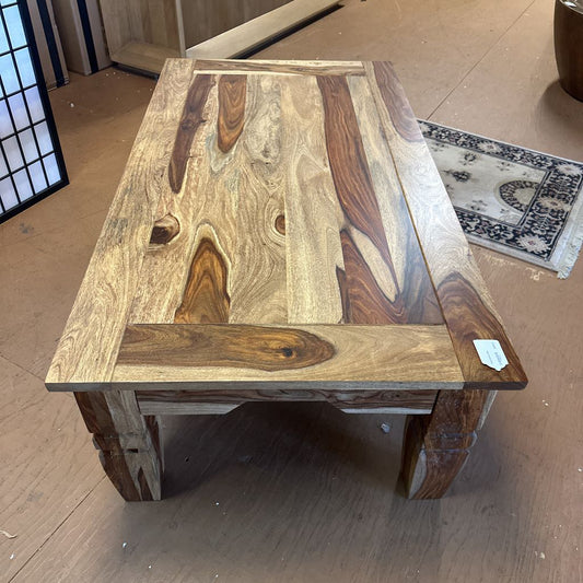 Wooden table with a natural, rustic finish on a wooden floor.