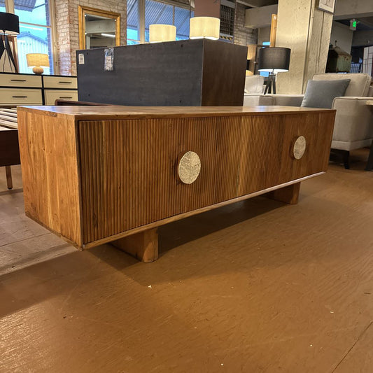 Wooden reception desk in a lobby setting with chairs and decor.