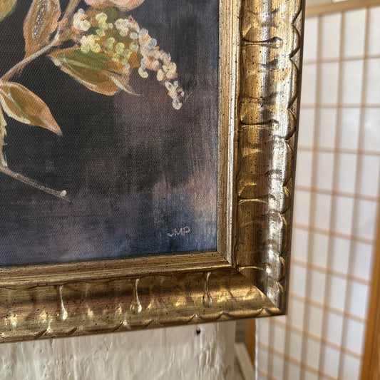 Close-up of a floral painting with a gold frame, showing signs of wear.