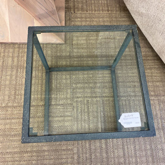Square glass table frame on a carpeted floor with a visible tag.