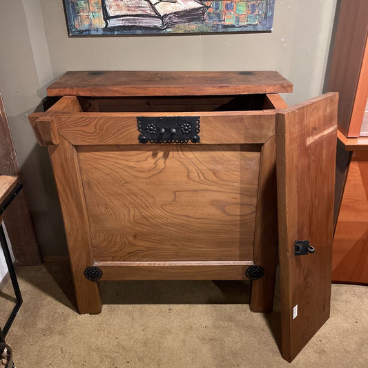 Wooden side table with open doors in a room setting