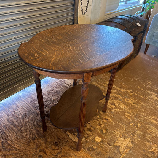 Wooden side table with a smaller matching table on a wooden floor.