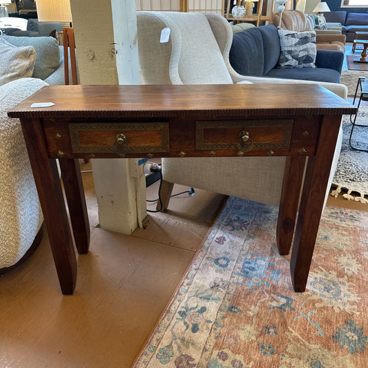 Wooden console table with two drawers in a room with furniture and decor.
