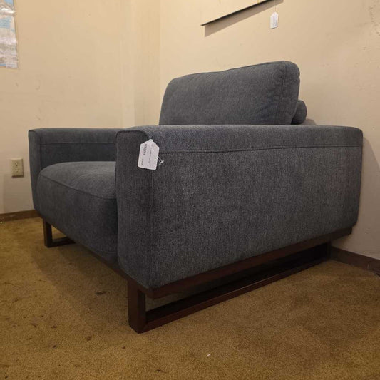 Gray sofa with a price tag in a room with beige walls and carpet.