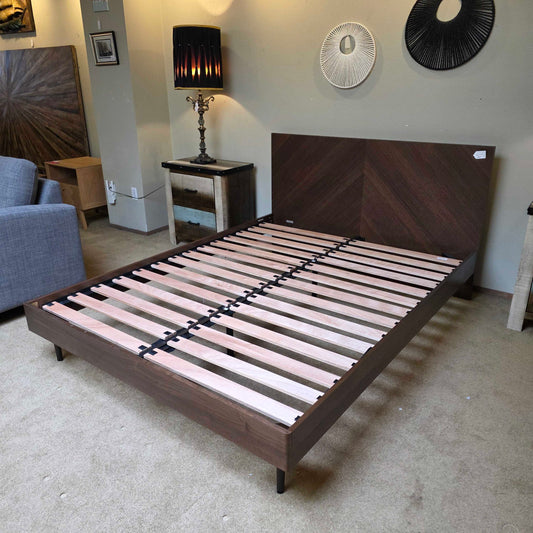 Wooden bed frame with slats in a room setting