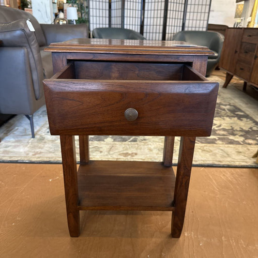 Wooden side table with a drawer in a room setting