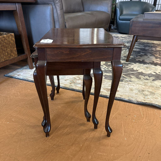 Wooden side table with curved legs in a living room setting