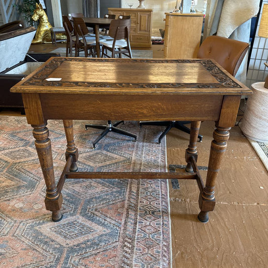 Wooden table with decorative inlay in a room with furniture and decor.