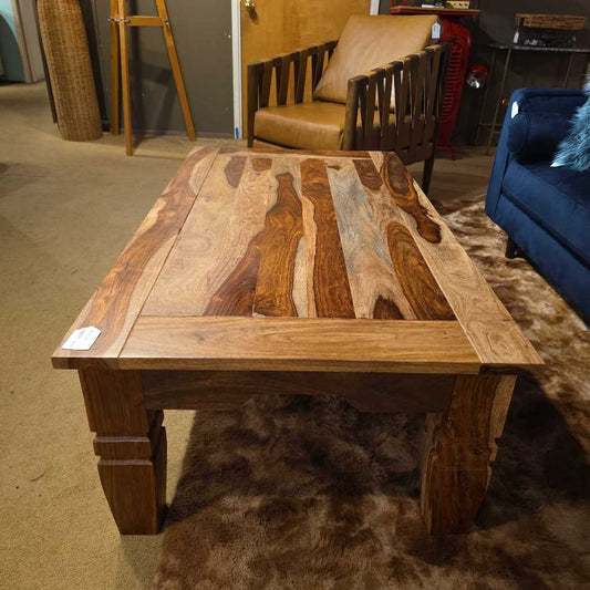 Wooden coffee table with a unique grain pattern in a room setting.