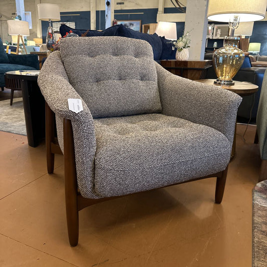 Gray armchair with wooden legs in a showroom setting